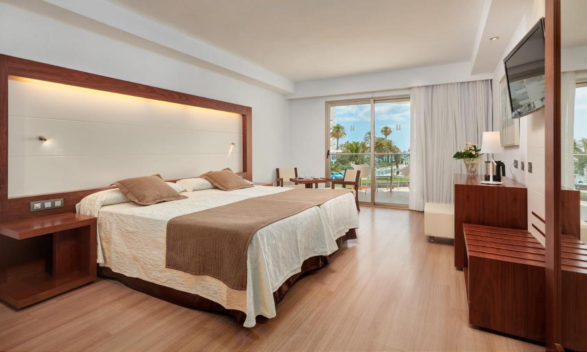 Un dormitorio con una cama grande y una ventana grande. en Hipotels Cala Millor Park, en Cala Millor