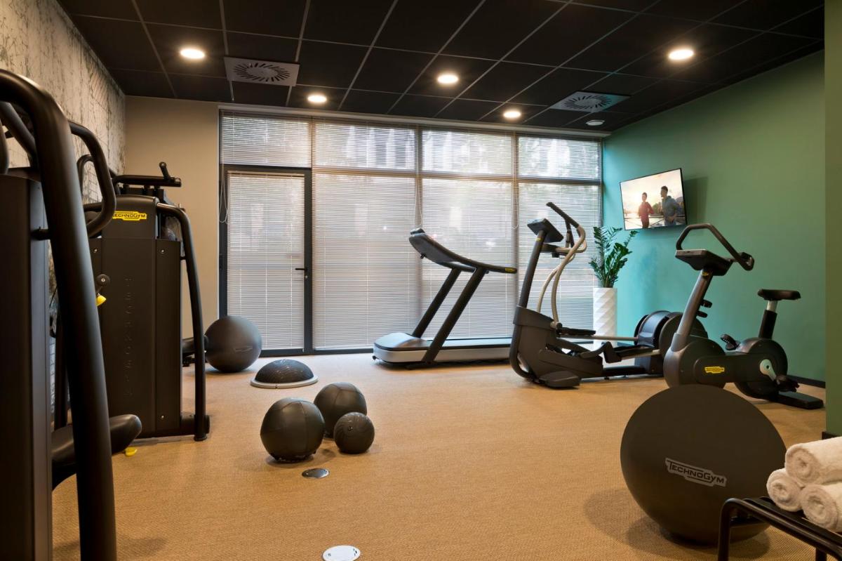 une salle de sport avec plusieurs appareils de musculation dans une pièce dans l'établissement Citadines Eurometropole Strasbourg, à Strasbourg 42 autres photos