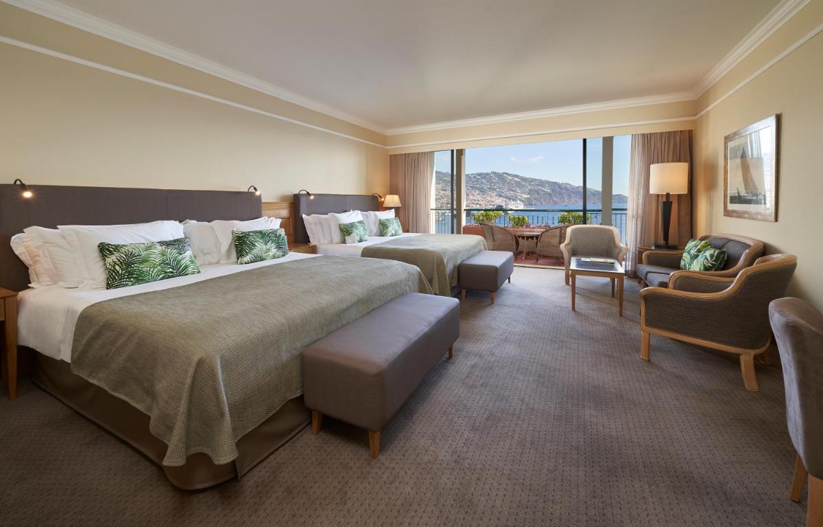 um quarto de hotel com duas camas e uma grande janela em The Cliff Bay - PortoBay no Funchal mais 61 fotografias