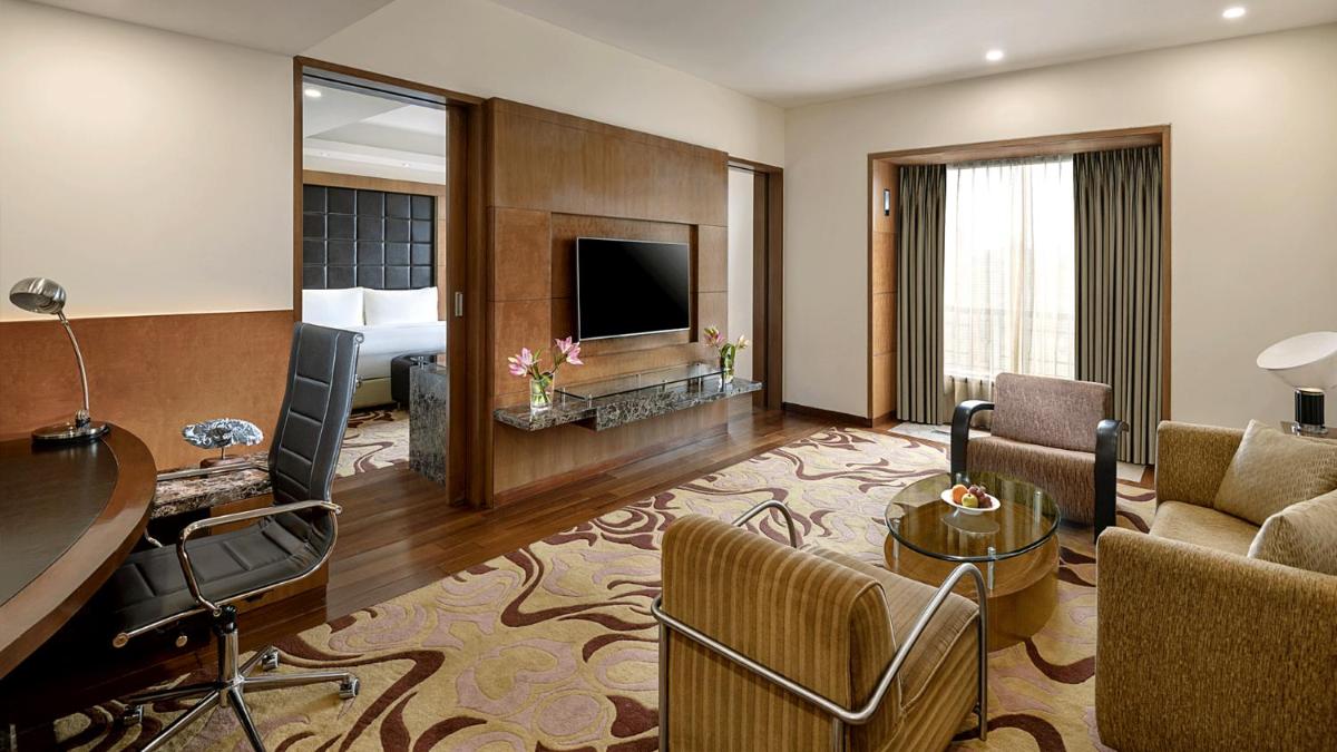 a large hotel room with a living room at Radisson Blu Plaza Delhi Airport in New Delhi a large hotel room with a living room at Radisson Blu Plaza Delhi Airport in New Delhi