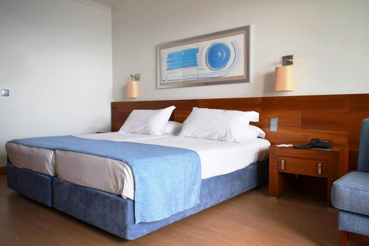 Uma cama ou camas num quarto em Madeira Regency Cliff - Adults Only