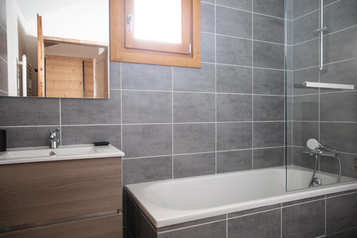 une salle de bain avec une baignoire et un lavabo dans l'établissement TERRESENS - LES EDELWEISS, à Vaujany 46 autres photos