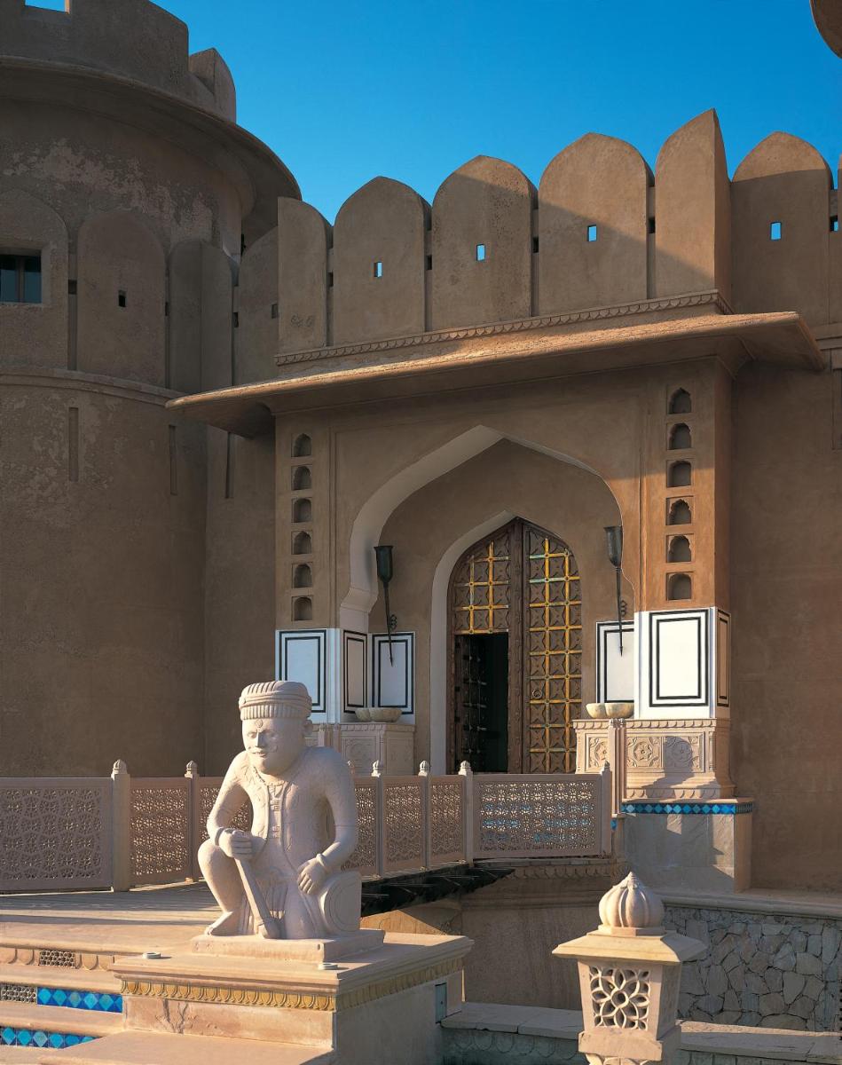 a statue sitting in front of a building at The Oberoi Rajvilas Jaipur in Jaipur