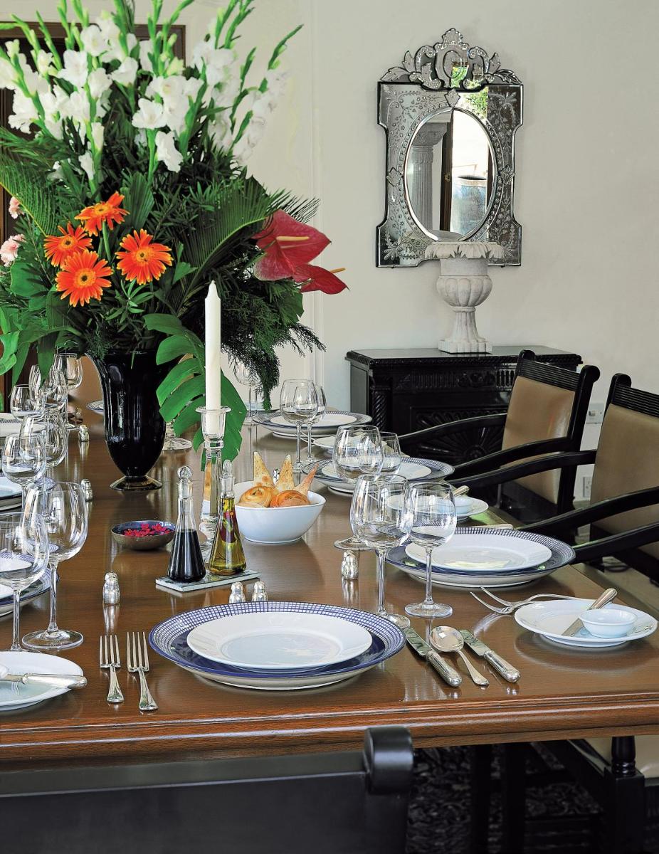 a table with plates and glasses and flowers on it at The Oberoi Rajvilas Jaipur in Jaipur