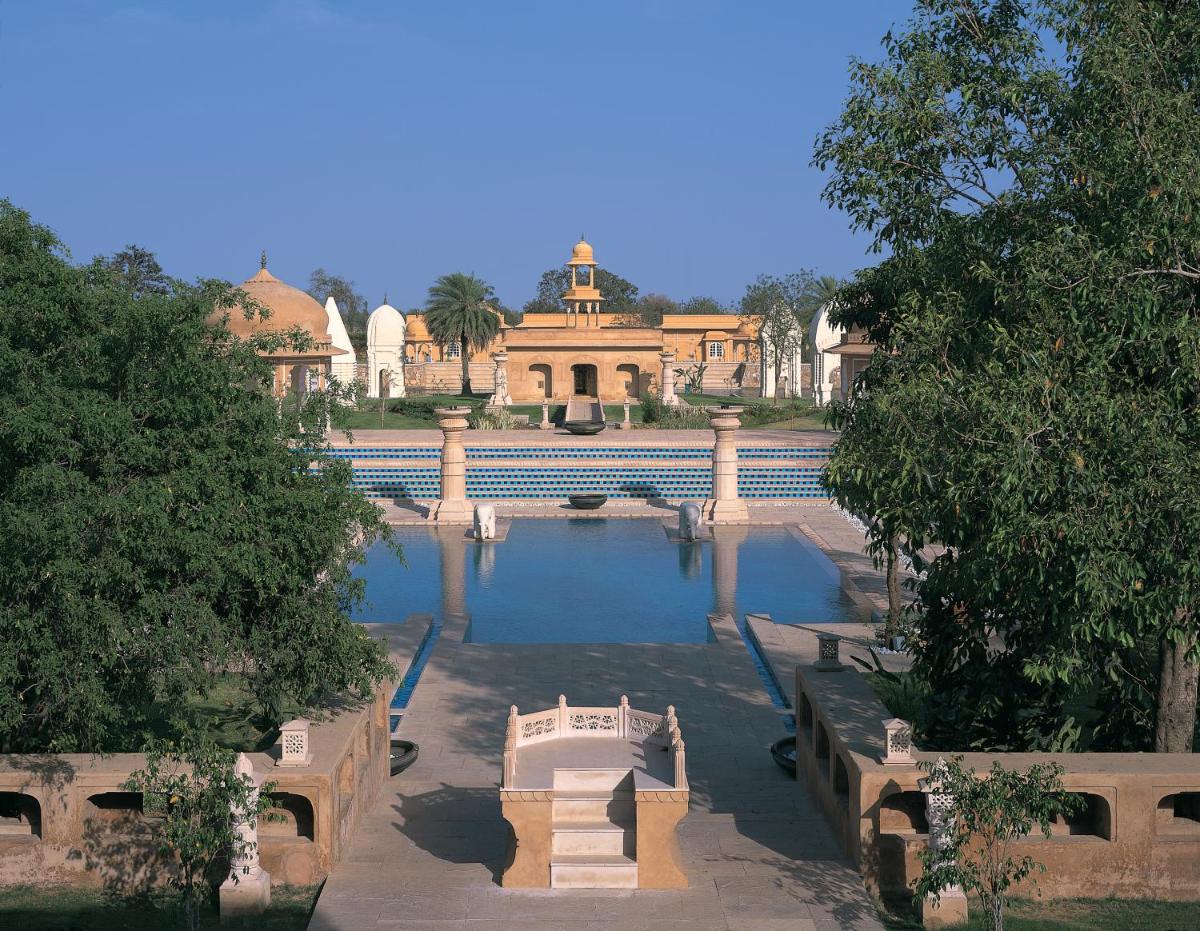 a large pool of water with a building in the background at The Oberoi Rajvilas Jaipur in Jaipur