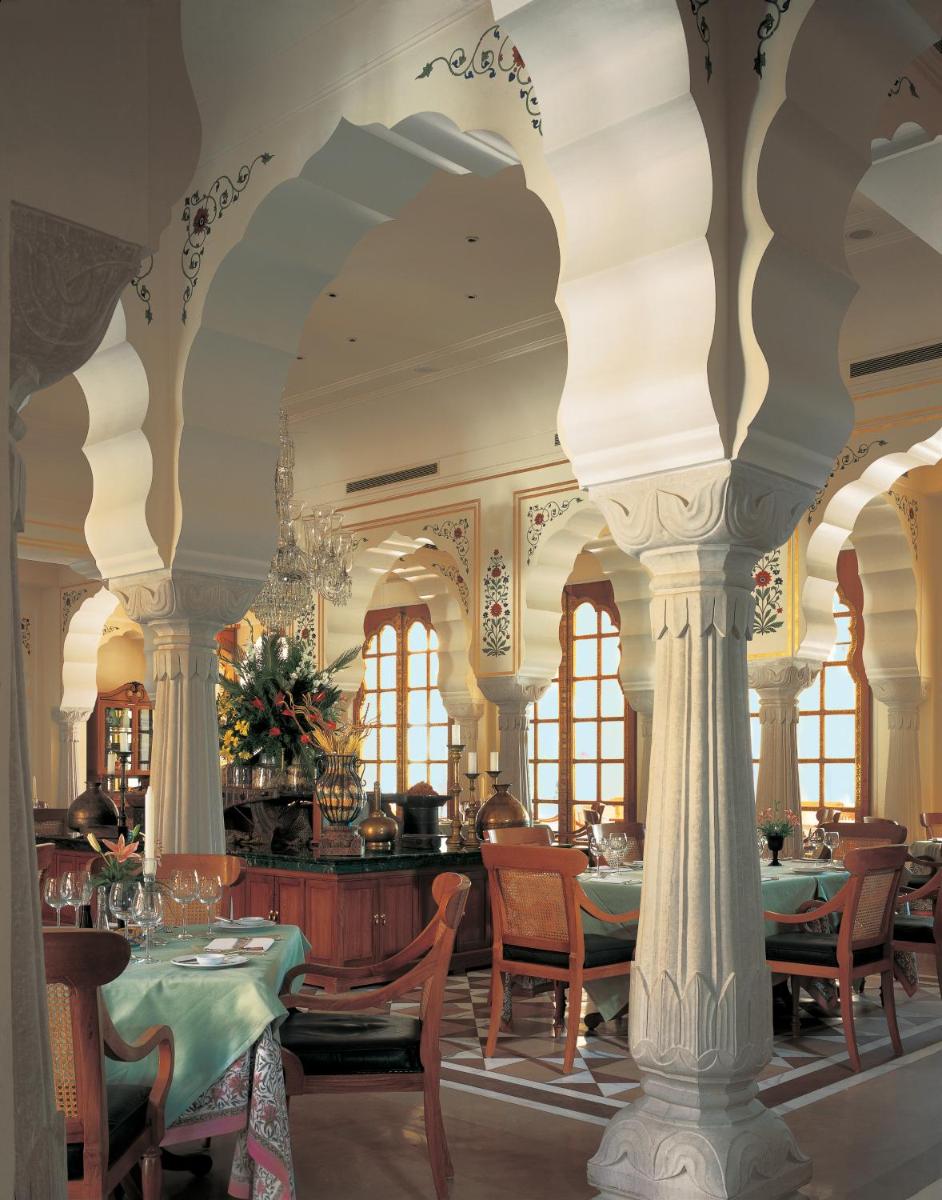 a dining room with columns and tables and chairs at The Oberoi Rajvilas Jaipur in Jaipur
