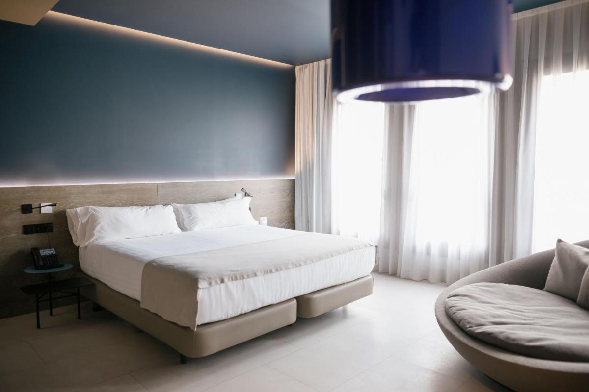 Un dormitorio con una cama grande y un sofá. en MYR Plaza Mercado & Spa, en Valencia