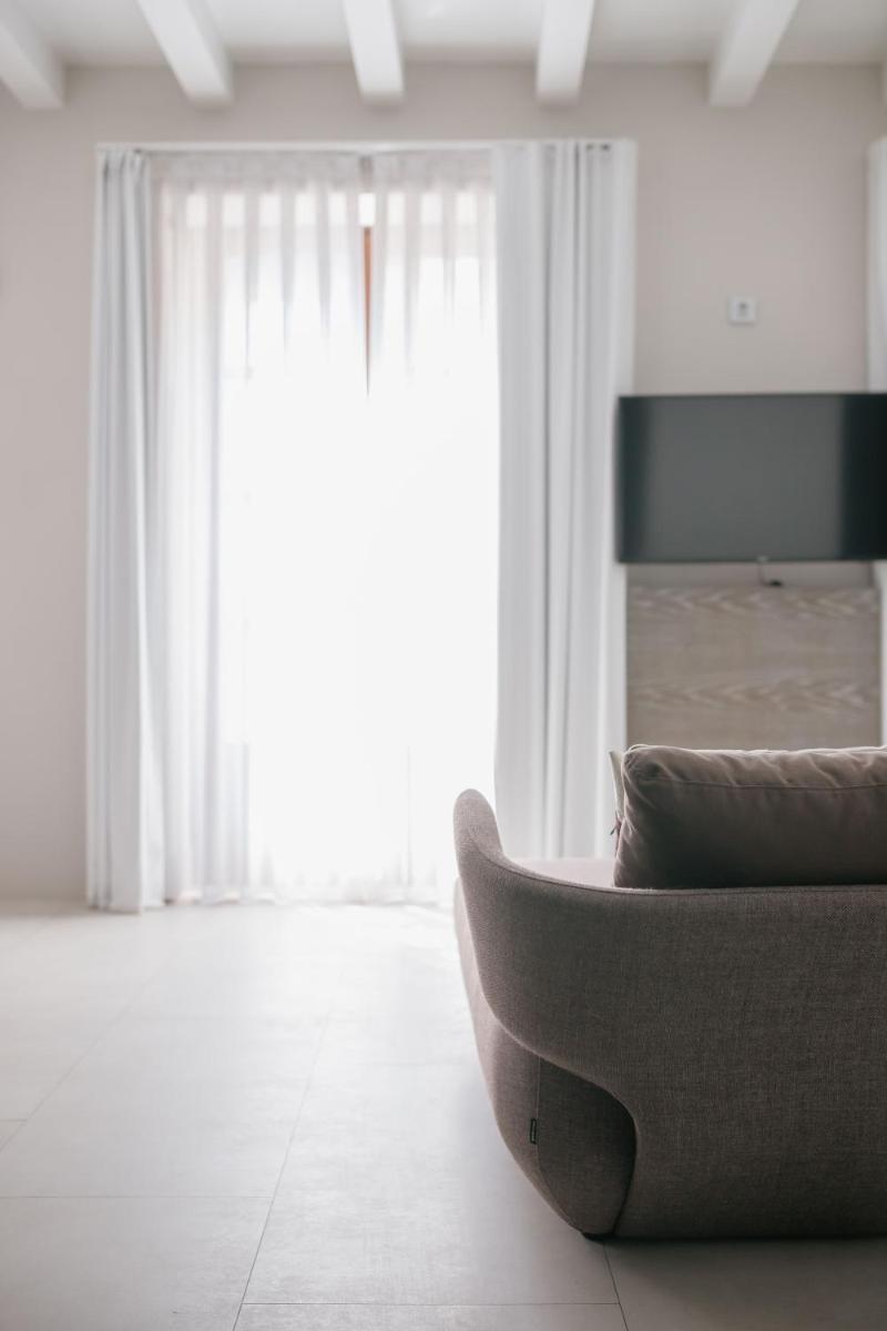 Una sala de estar con un sofá y una ventana grande. en MYR Plaza Mercado & Spa, en Valencia