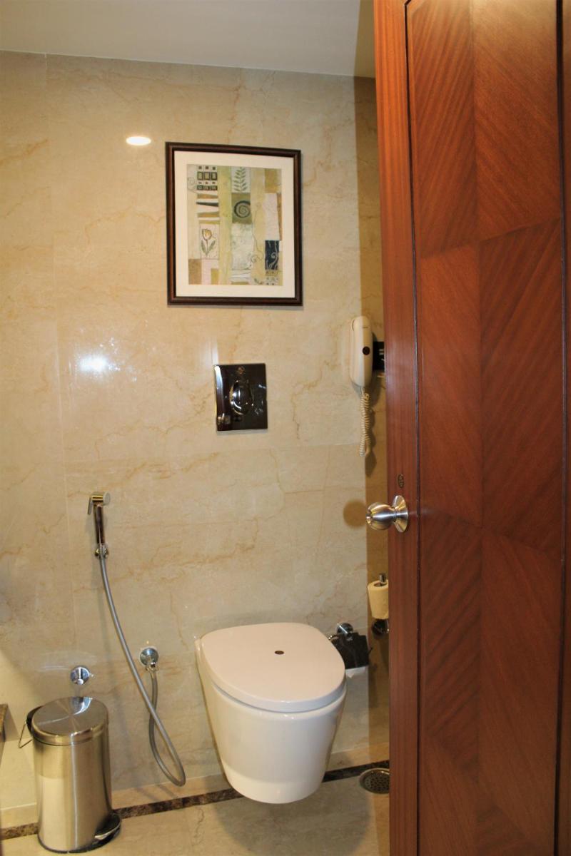 a bathroom with a toilet and a picture on the wall at The Accord Metropolitan in Chennai