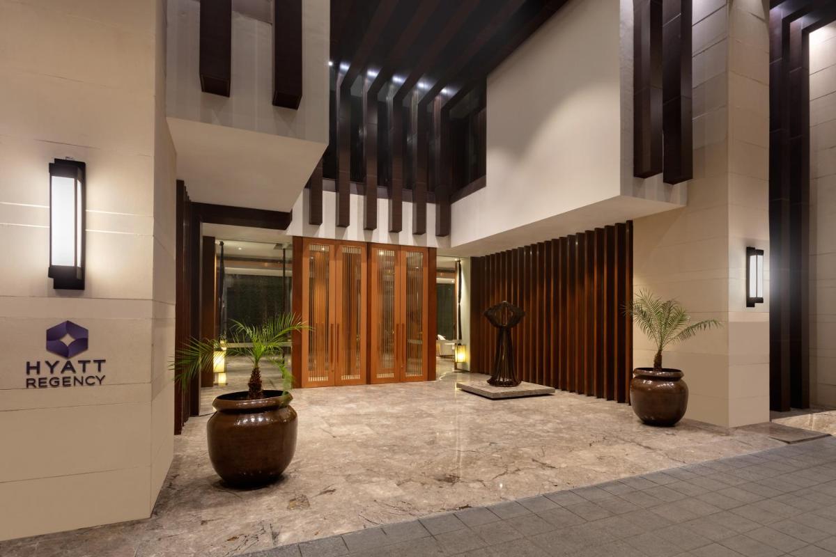 a lobby with two potted plants in a building at Hyatt Regency Amritsar Hotel & Spa in Amritsar