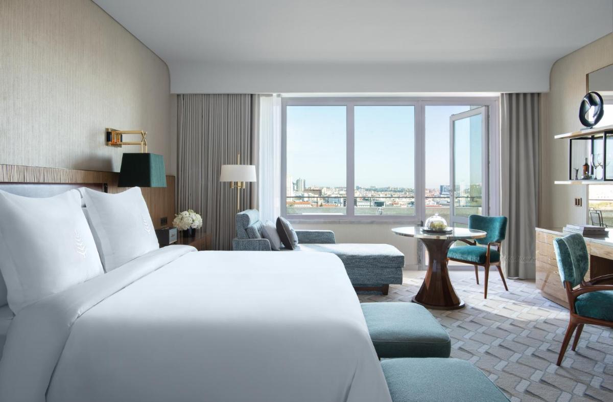um quarto de hotel com uma cama e uma sala de estar em Four Seasons Hotel Ritz Lisbon em Lisboa