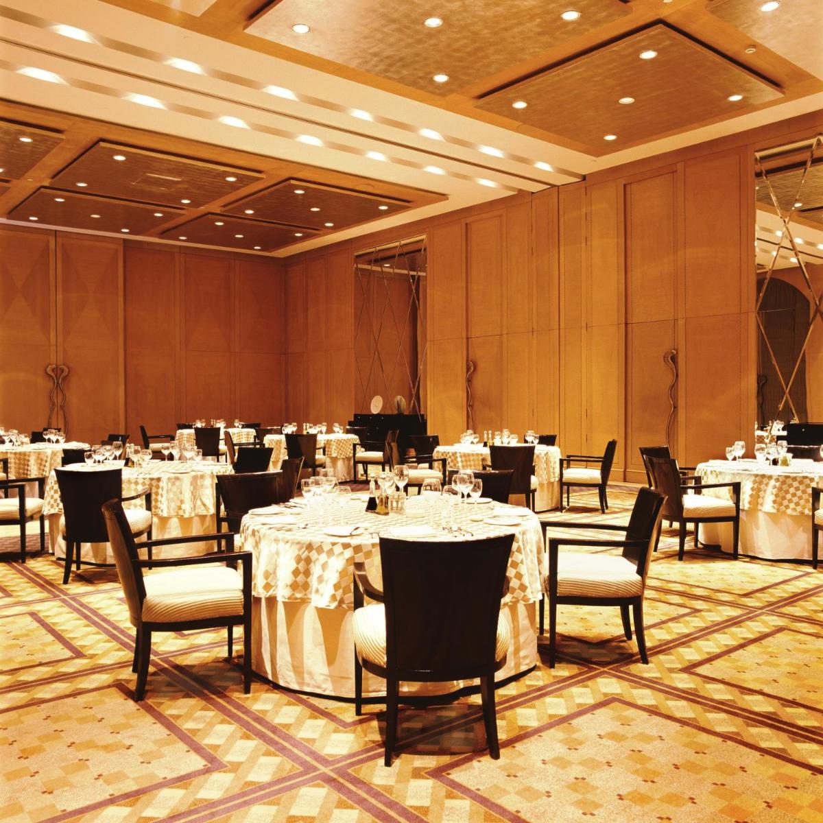 a banquet hall with white tables and chairs at Trident Gurgaon in Gurgaon