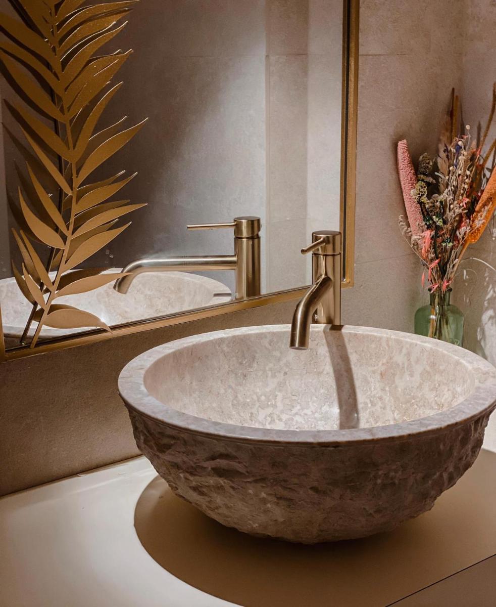 Un baño con un lavabo de piedra y un espejo. en Portomar Apartments - 4-Star Superior Hotel, en Portocolom