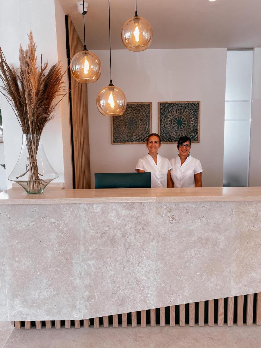 Dos mujeres están detrás de un mostrador de recepción. en Portomar Apartments - 4-Star Superior Hotel, en Portocolom 141 fotos más