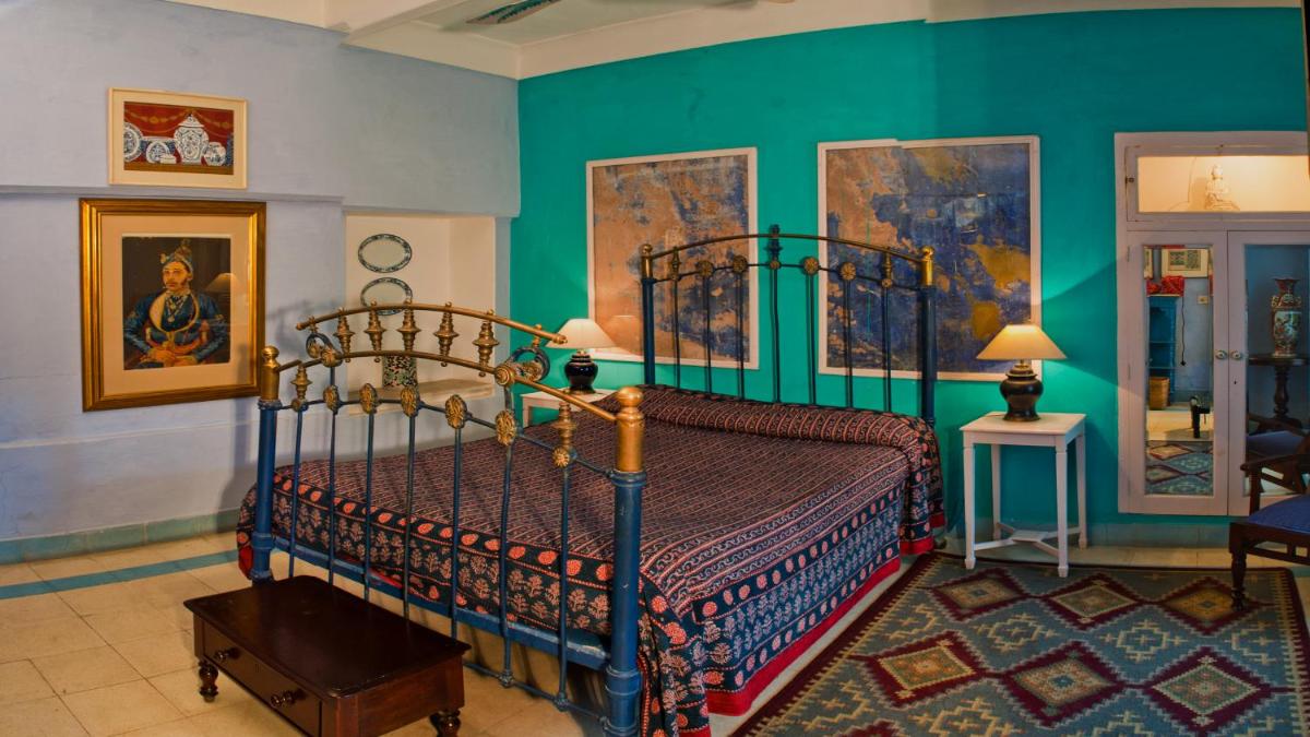 a bedroom with a bed and a green wall at Neemrana Fort-Palace in Neemrana