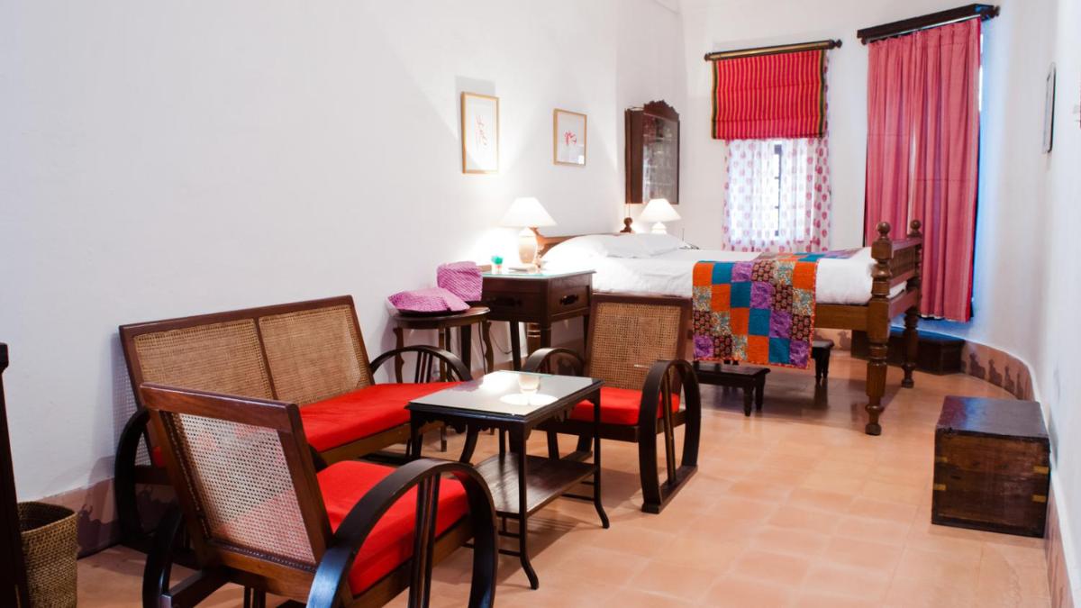a room with a bed and a table and chairs at Neemrana Fort-Palace in Neemrana