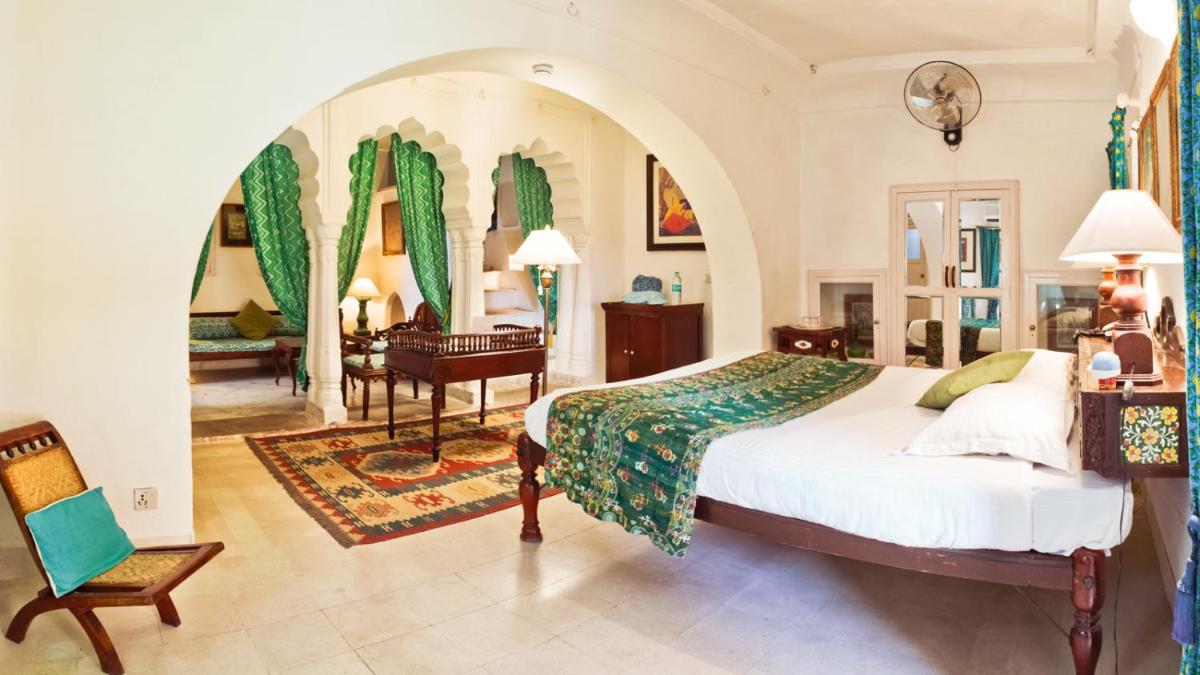 a bedroom with a bed and a piano in a room at Neemrana Fort-Palace in Neemrana