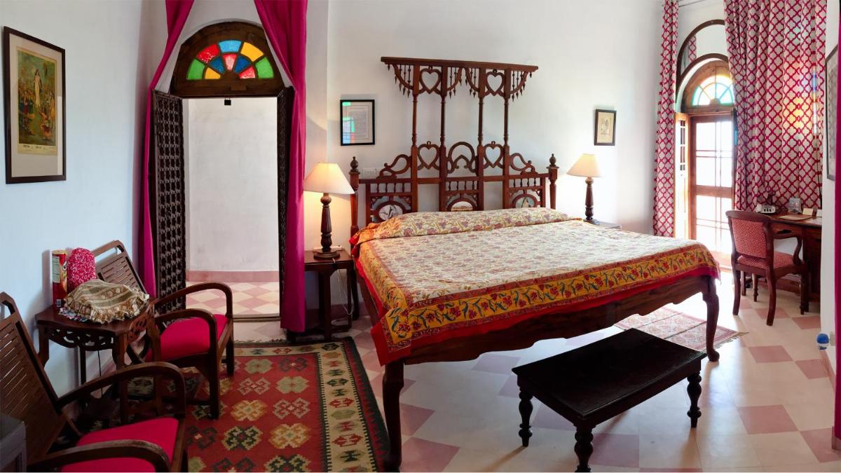 a bedroom with a bed and a table and chairs at Neemrana Fort-Palace in Neemrana