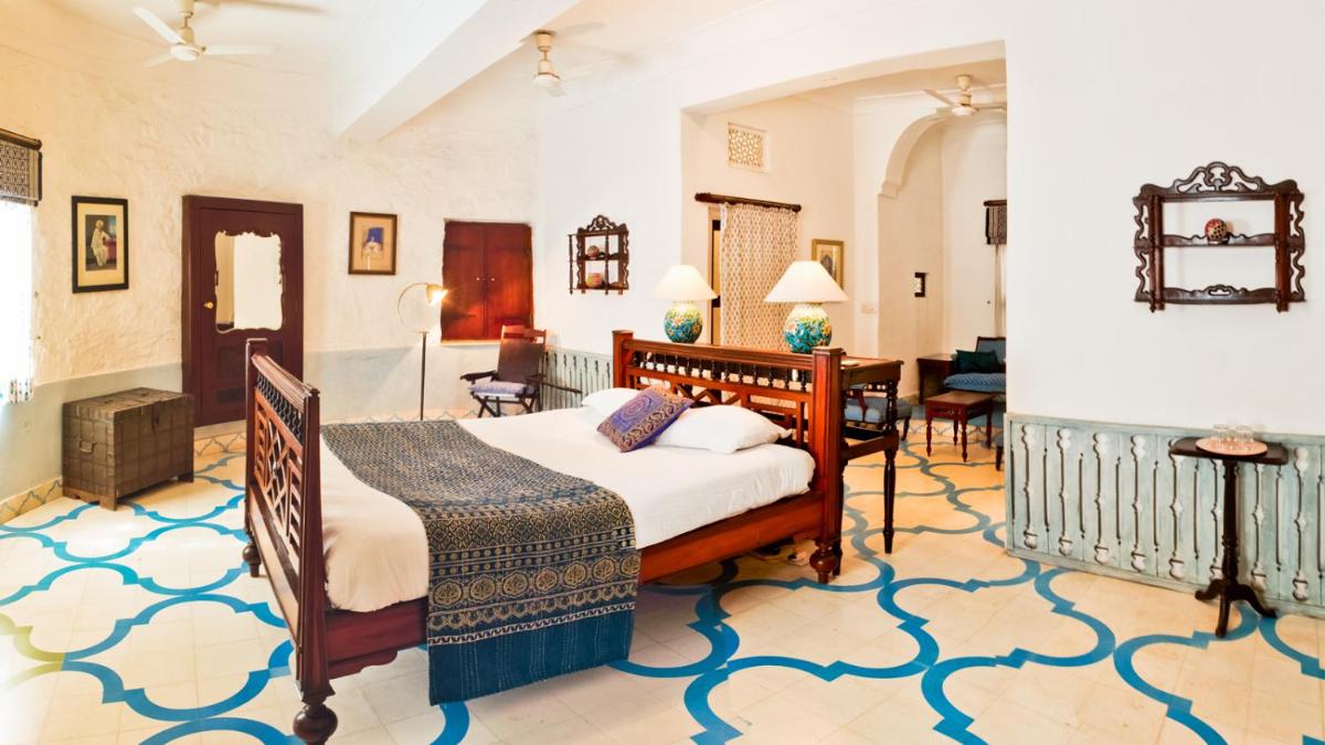 a bedroom with a bed and a living room at Neemrana Fort-Palace in Neemrana