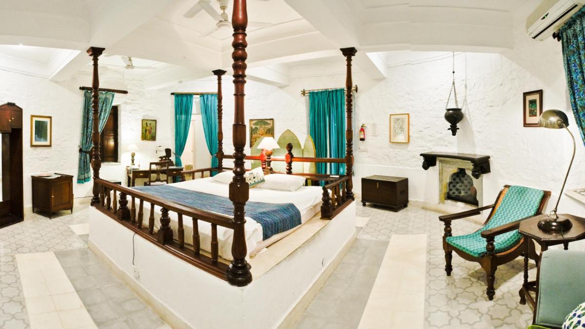 a bedroom with a large bed and a fireplace at Neemrana Fort-Palace in Neemrana