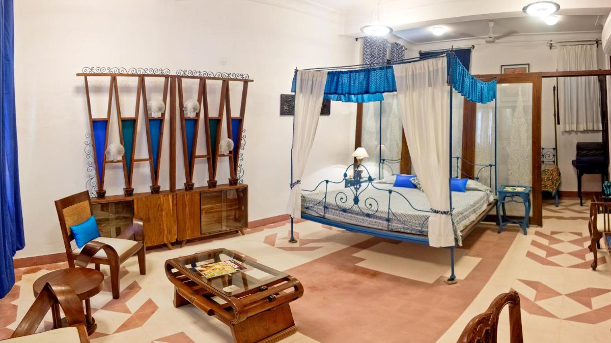 a bedroom with a canopy bed and a living room at Neemrana Fort-Palace in Neemrana