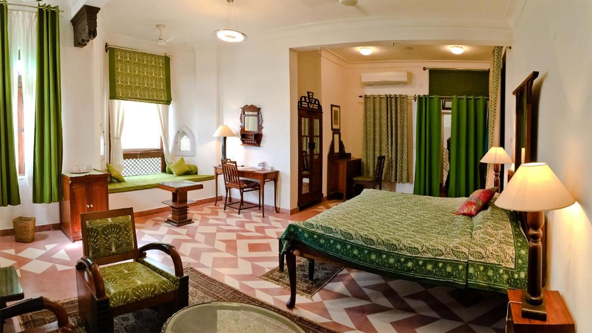 a bedroom with a bed and a chair in a room at Neemrana Fort-Palace in Neemrana