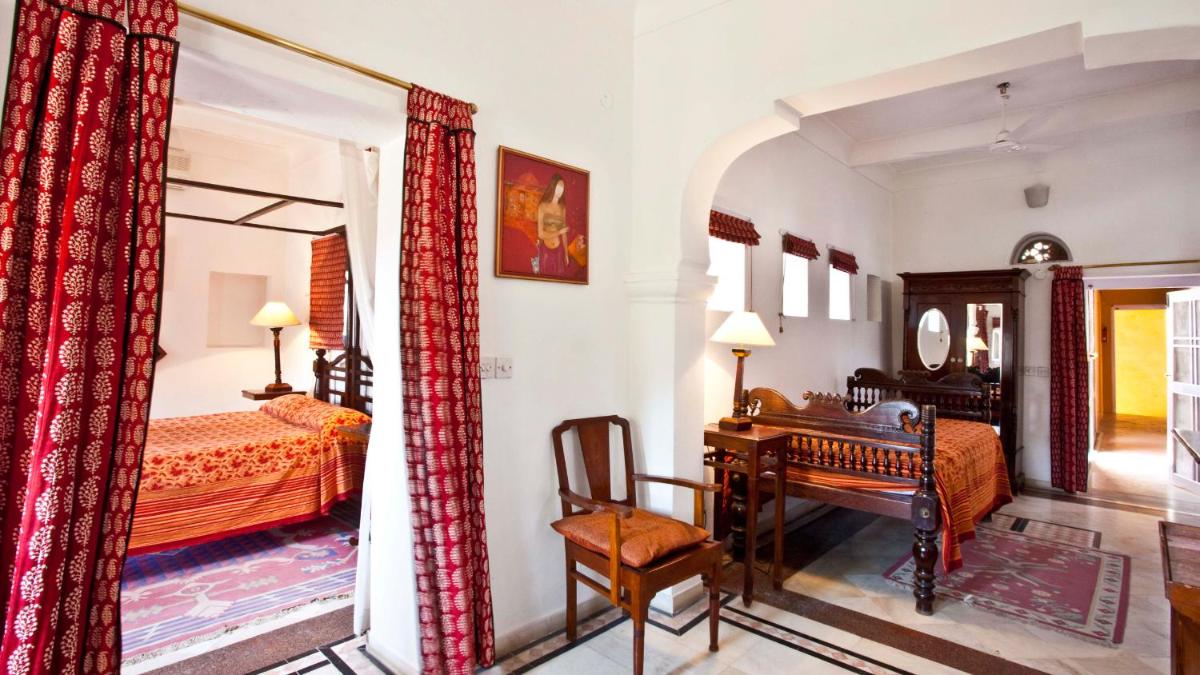 a bedroom with a desk and a bedroom with a bed and a table at Neemrana Fort-Palace in Neemrana