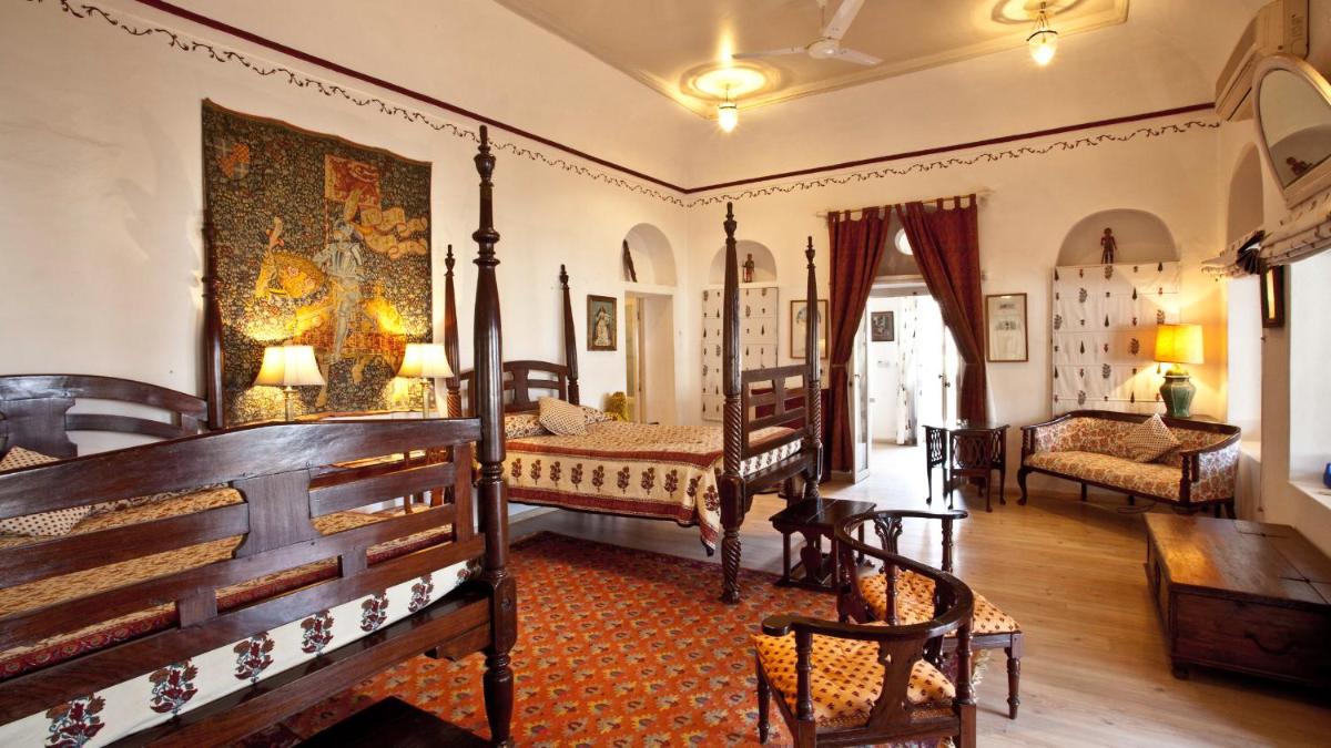 a room with two beds and a living room at Neemrana Fort-Palace in Neemrana