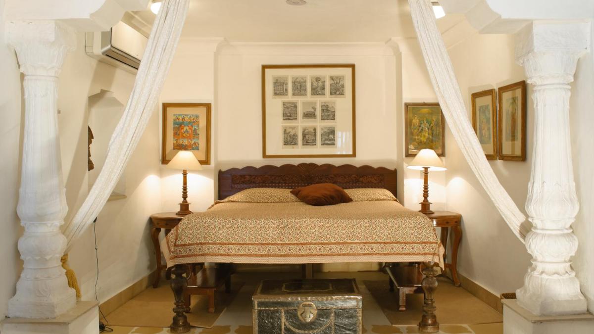 a bedroom with a bed with a dog sleeping on it at Neemrana Fort-Palace in Neemrana