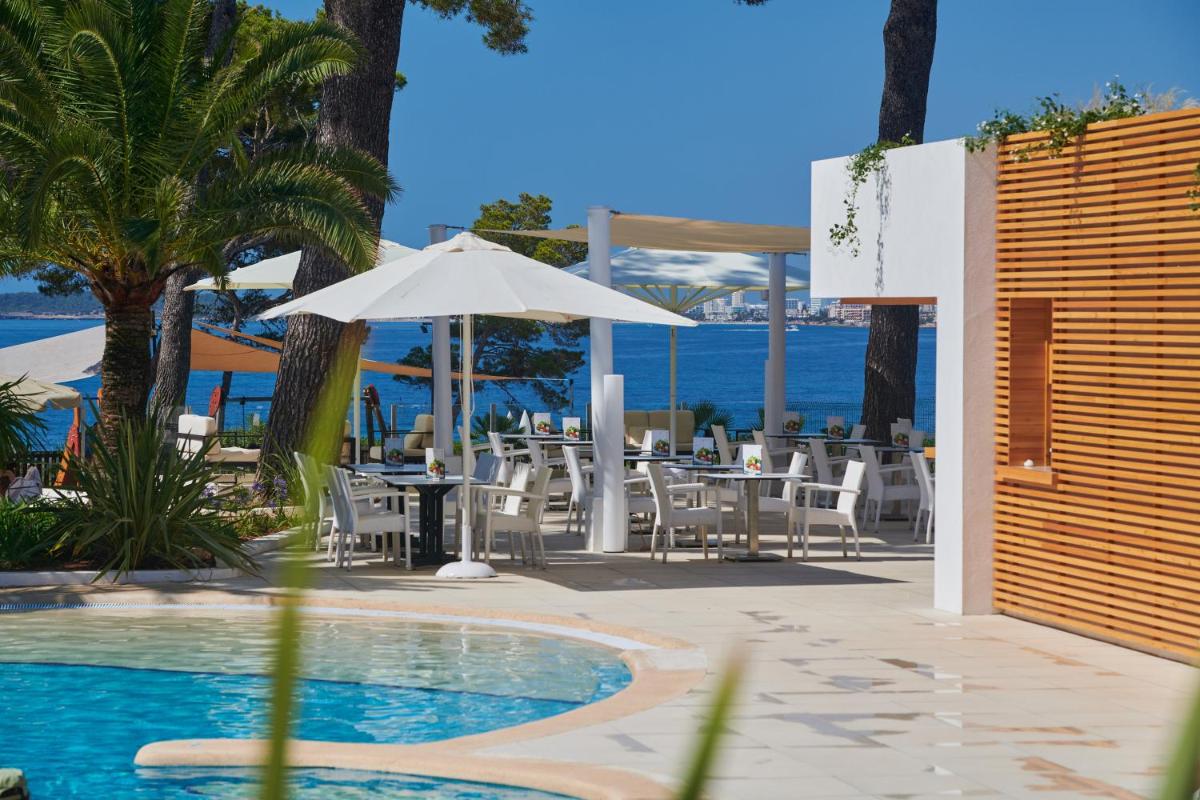 Un patio con una mesa y sillas y una sombrilla. en Hipotels Eurotel Punta Rotja Spa-Golf, en Costa des Pins