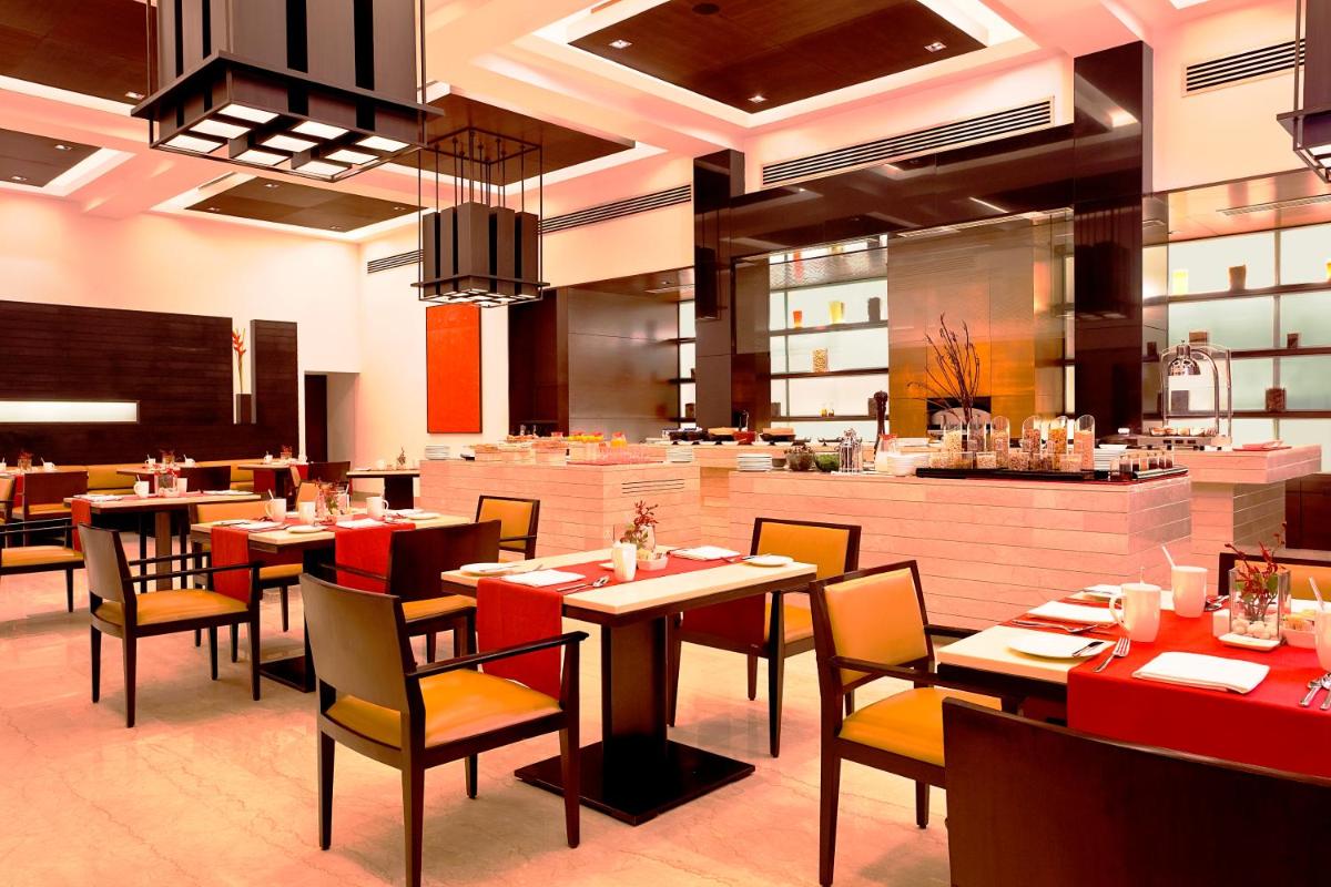 a dining room with tables and chairs in a restaurant at Trident Agra in Agra
