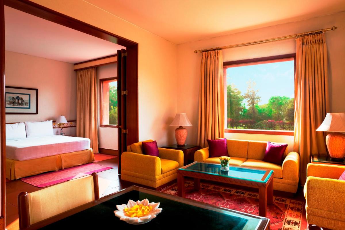 a hotel room with a bed and a living room at Trident Agra in Agra