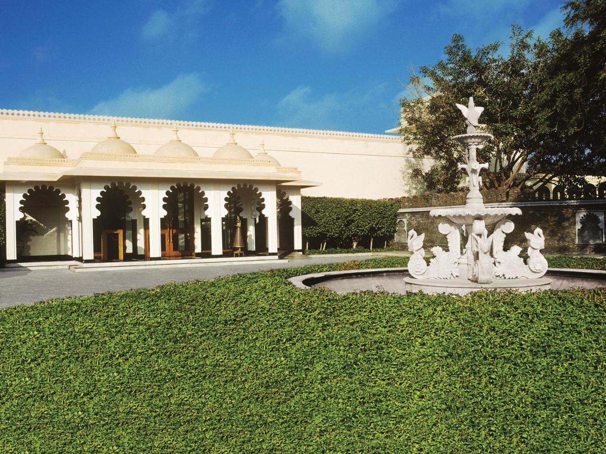 a fountain in the grass in front of a building at Trident Udaipur in Udaipur