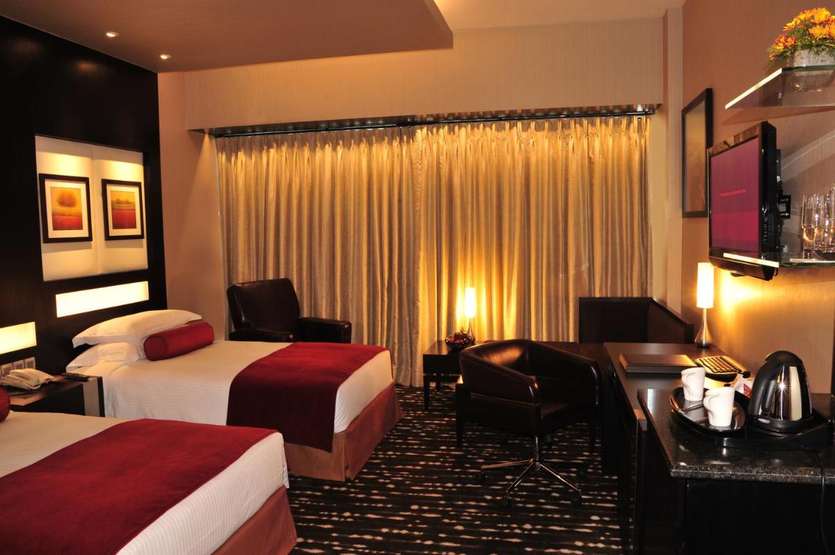 a hotel room with two beds and a desk at The Oterra in Bengaluru