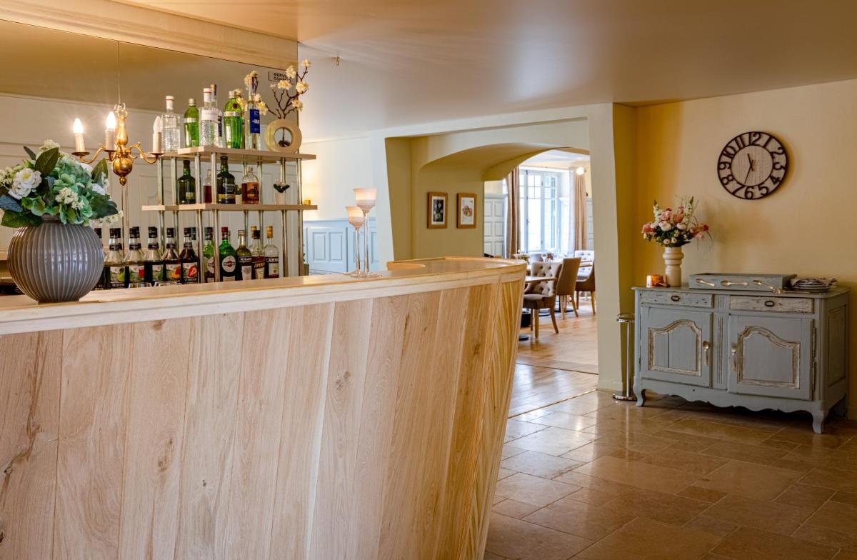 - un bar dans une salle avec une table et des bouteilles de vin dans l'établissement Logis Relais de la Source, à Saint-Seine-lʼAbbaye