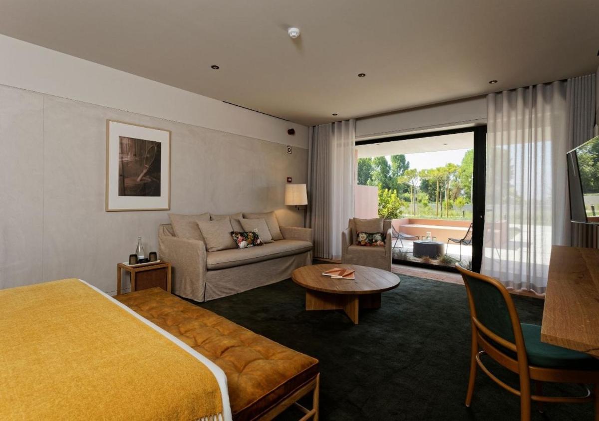um quarto de hotel com uma cama e um sofá em Montebelo Vista Alegre Ílhavo Hotel em Ílhavo