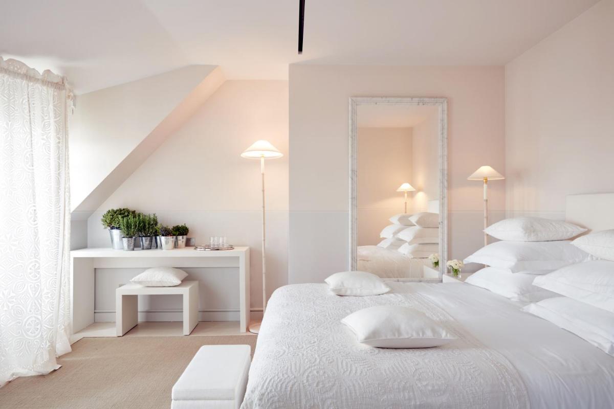 une chambre blanche avec un lit blanc et un escalier dans l'établissement Monsieur George Hotel & Spa - Champs-Elysées, à Paris