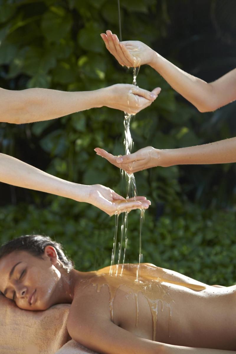 a man laying in a pool with water pouring from his hands at Hard Rock Hotel Goa Calangute in Calangute