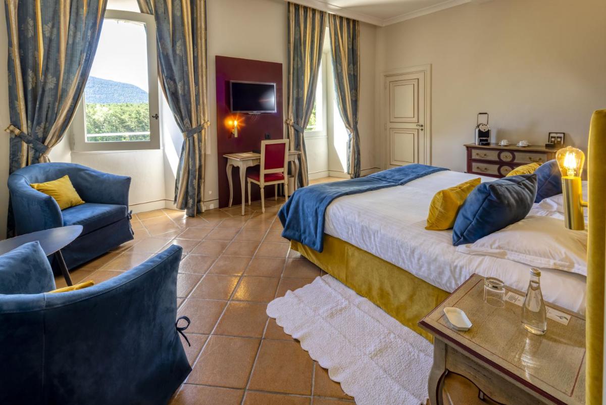 une chambre avec un lit, une chaise et une table dans l'établissement Château et Golf De Taulane, à La Martre