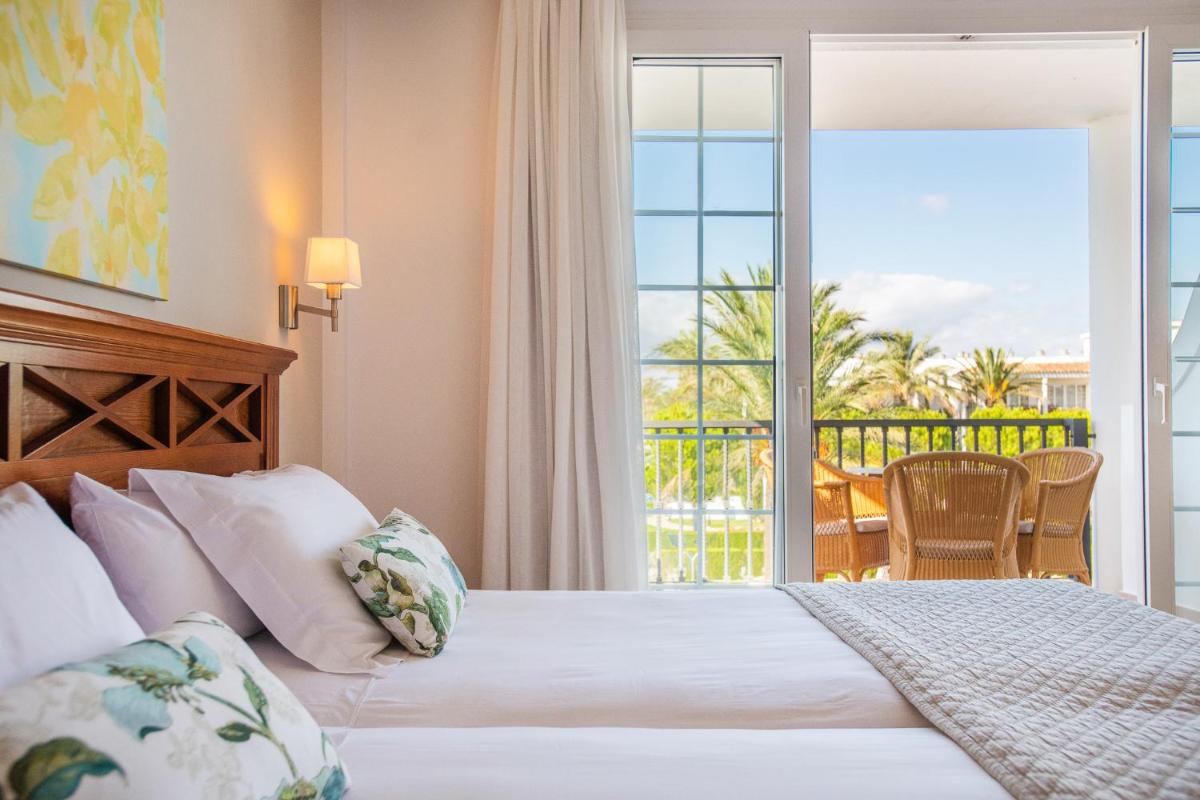 una habitación de hotel con una cama y un balcón en Inturotel Sa Marina, en Cala d´Or