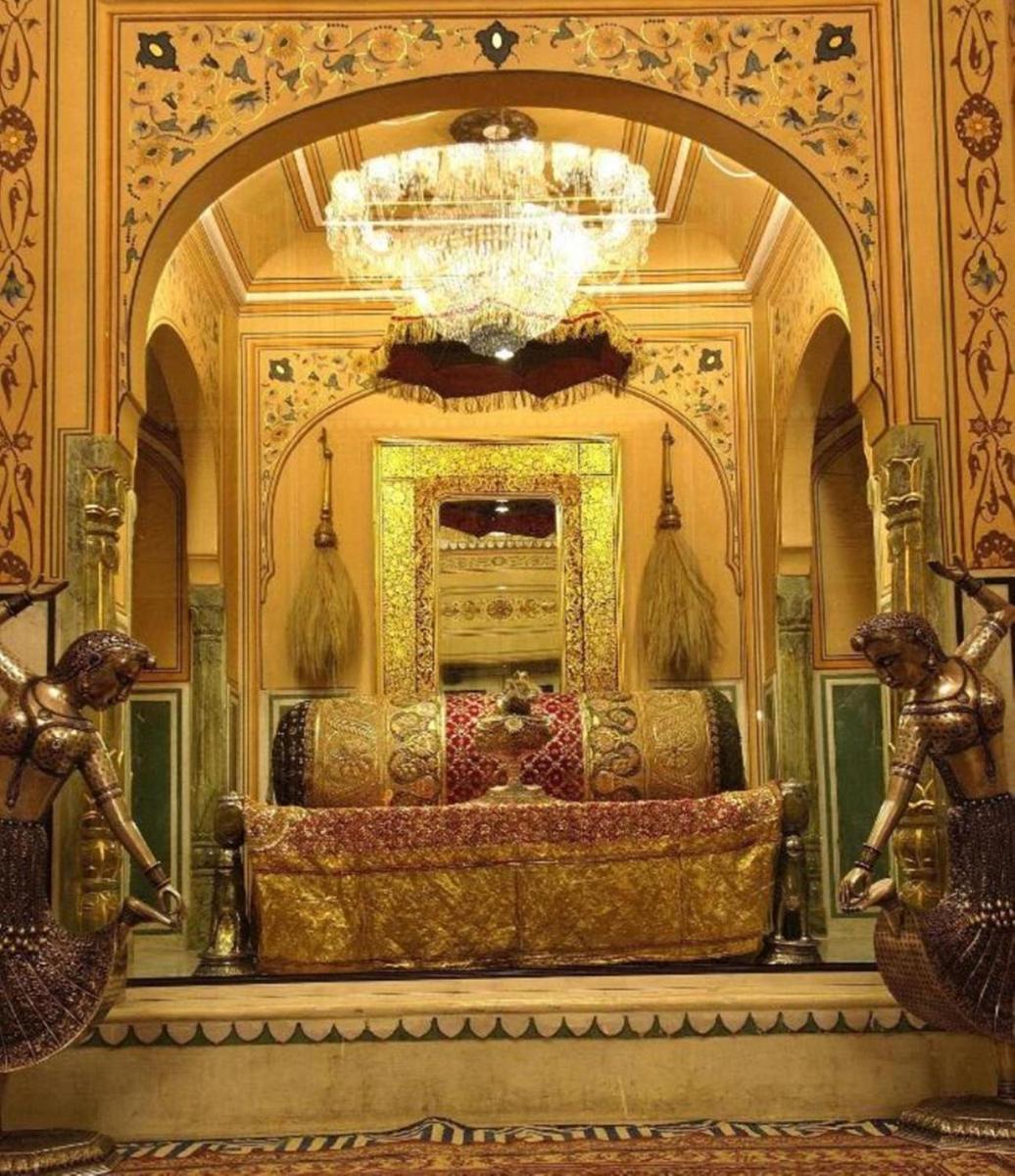 a large room with a chandelier and a bed at The Raj Palace (Small Luxury Hotels of the World) in Jaipur