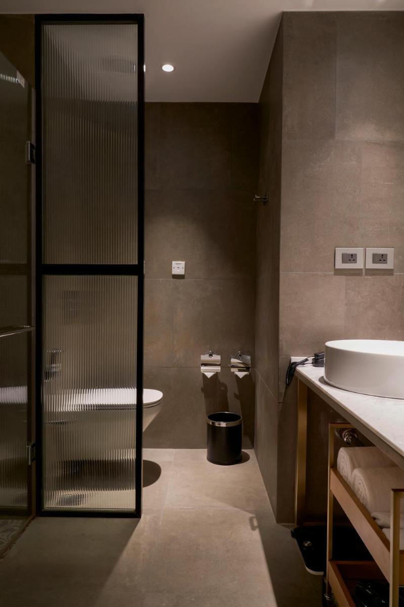 a bathroom with a shower and a sink and a toilet at Holiday Inn Goa Candolim in Candolim a bathroom with a shower and a sink and a toilet at Holiday Inn Goa Candolim in Candolim