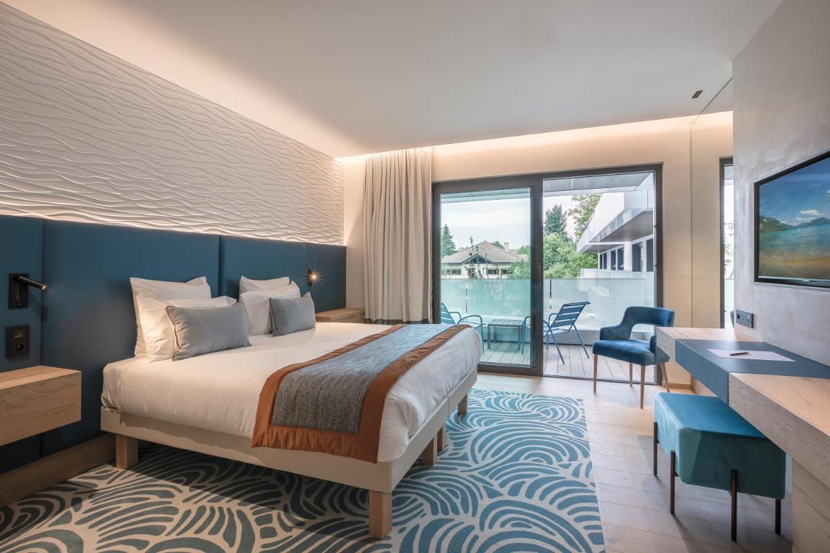 une chambre d'hôtel avec un lit et un balcon dans l'établissement Rivage Hôtel & Spa Annecy, à Annecy