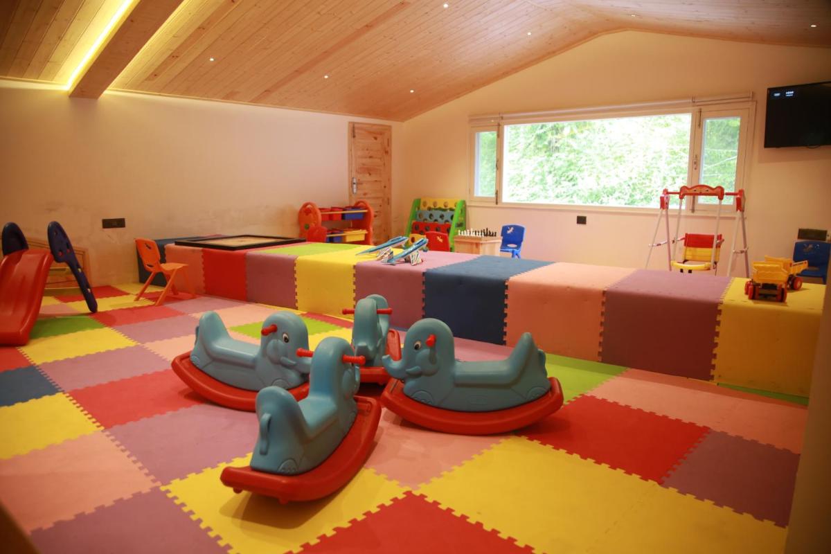 a childs room with two beds and two play equipment at The Orchid Shimla in Shimla