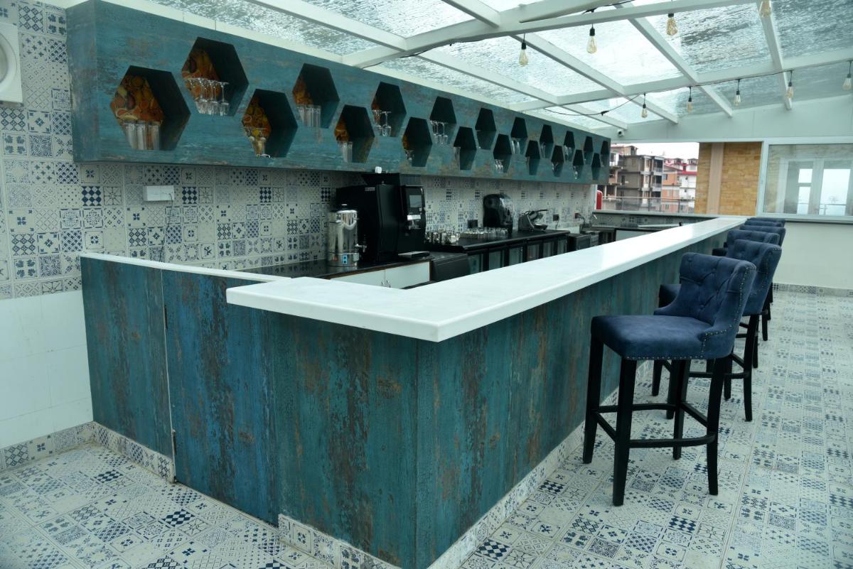 a kitchen with a bar with chairs in a room at The Orchid Shimla in Shimla