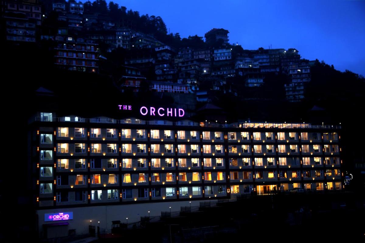 a lit up hotel building at night with lights at The Orchid Shimla in Shimla