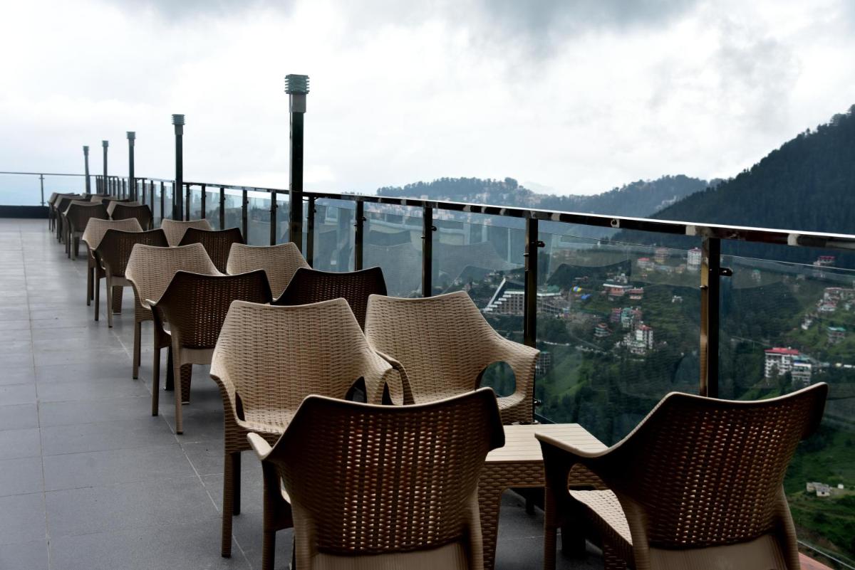 a row of chairs sitting on top of a balcony at The Orchid Shimla in Shimla
