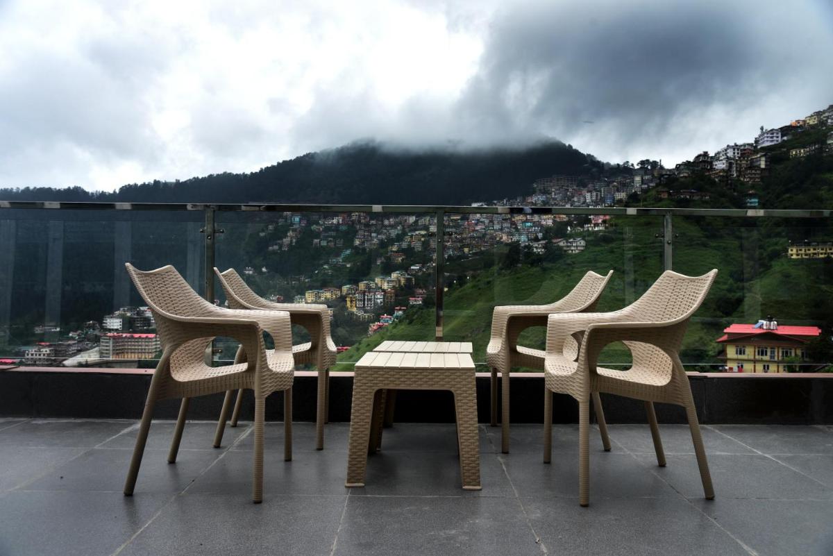 a group of chairs and a table on a balcony at The Orchid Shimla in Shimla
