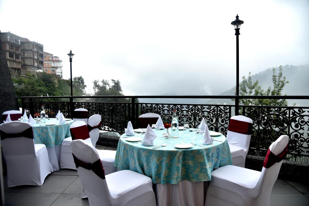 a set of tables and chairs on a balcony at The Orchid Shimla in Shimla