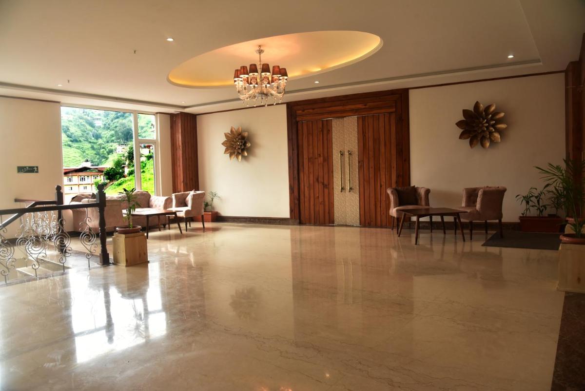 a lobby with a table and chairs and a chandelier at The Orchid Shimla in Shimla
